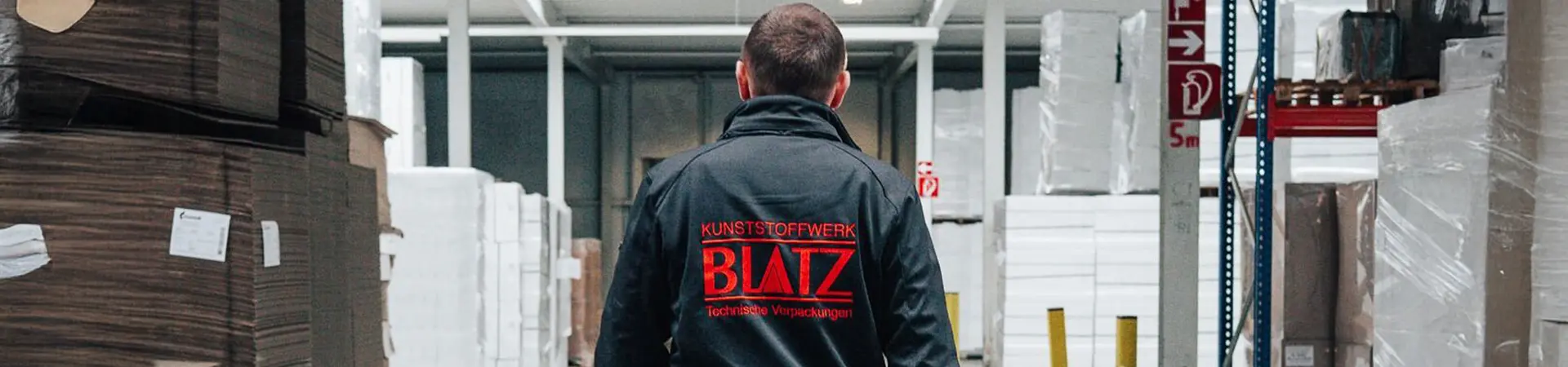 Ein Mitarbeiter der Blatz Kunststoffwerk GmbH steht im Lager für effiziente Lagerhaltung und flexible Verpackungslösungen